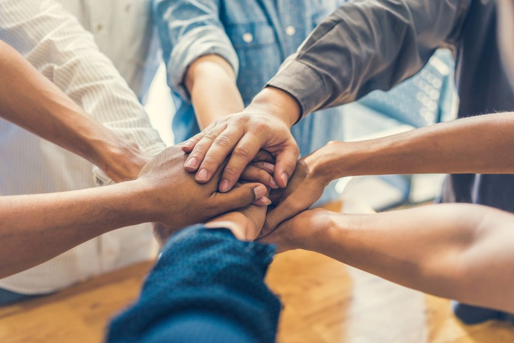 business people making pile of hands